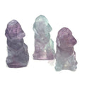 Three XL Fluorite hound Dogs gemstone carving on white background, front view.