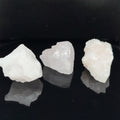 Three raw mangano calcite (6-11g) on a black background, front view. 