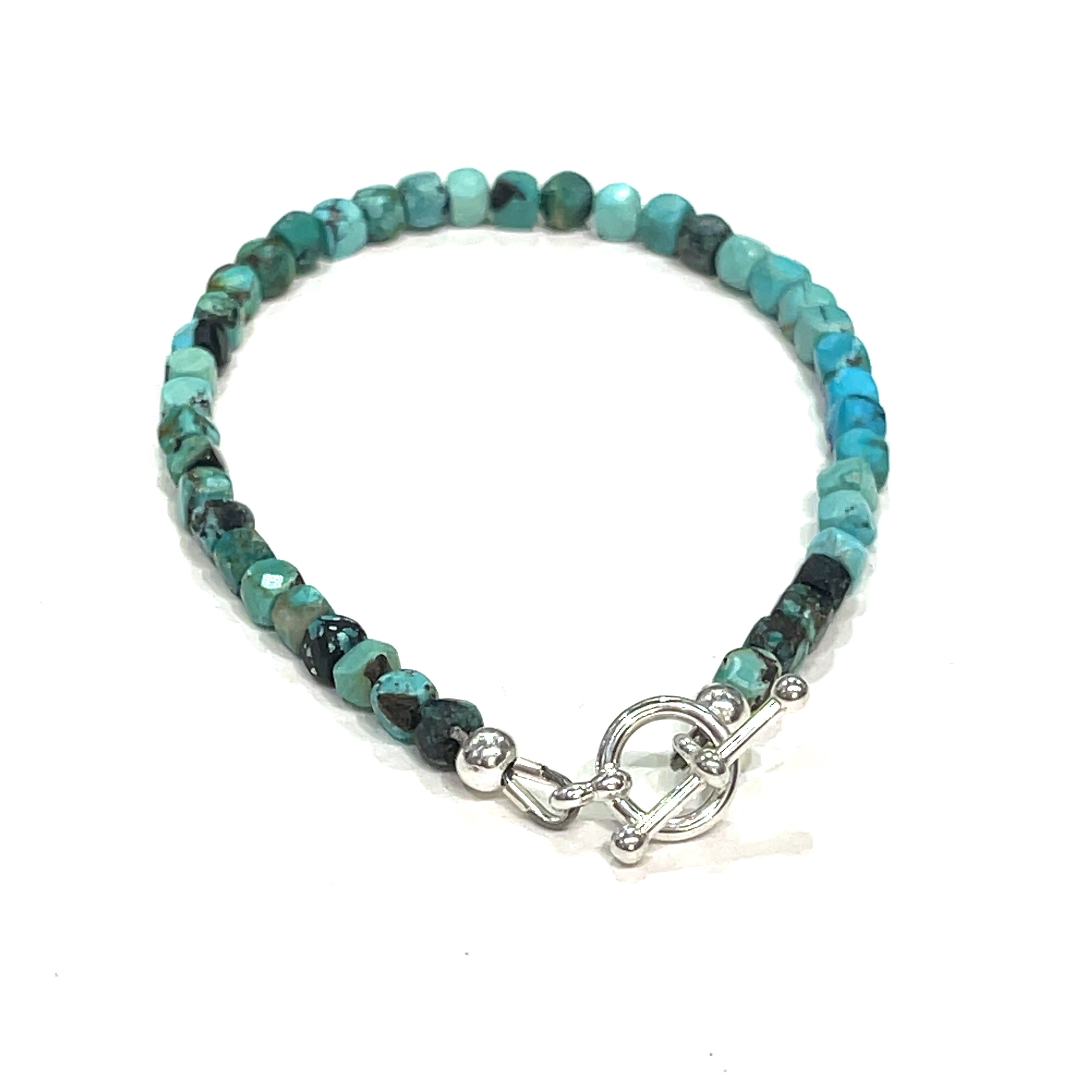 Top-grade Turquoise faceted cubed  beads strung on durable Beadalon wire with a sterling silver toggle on a white background  back view. 