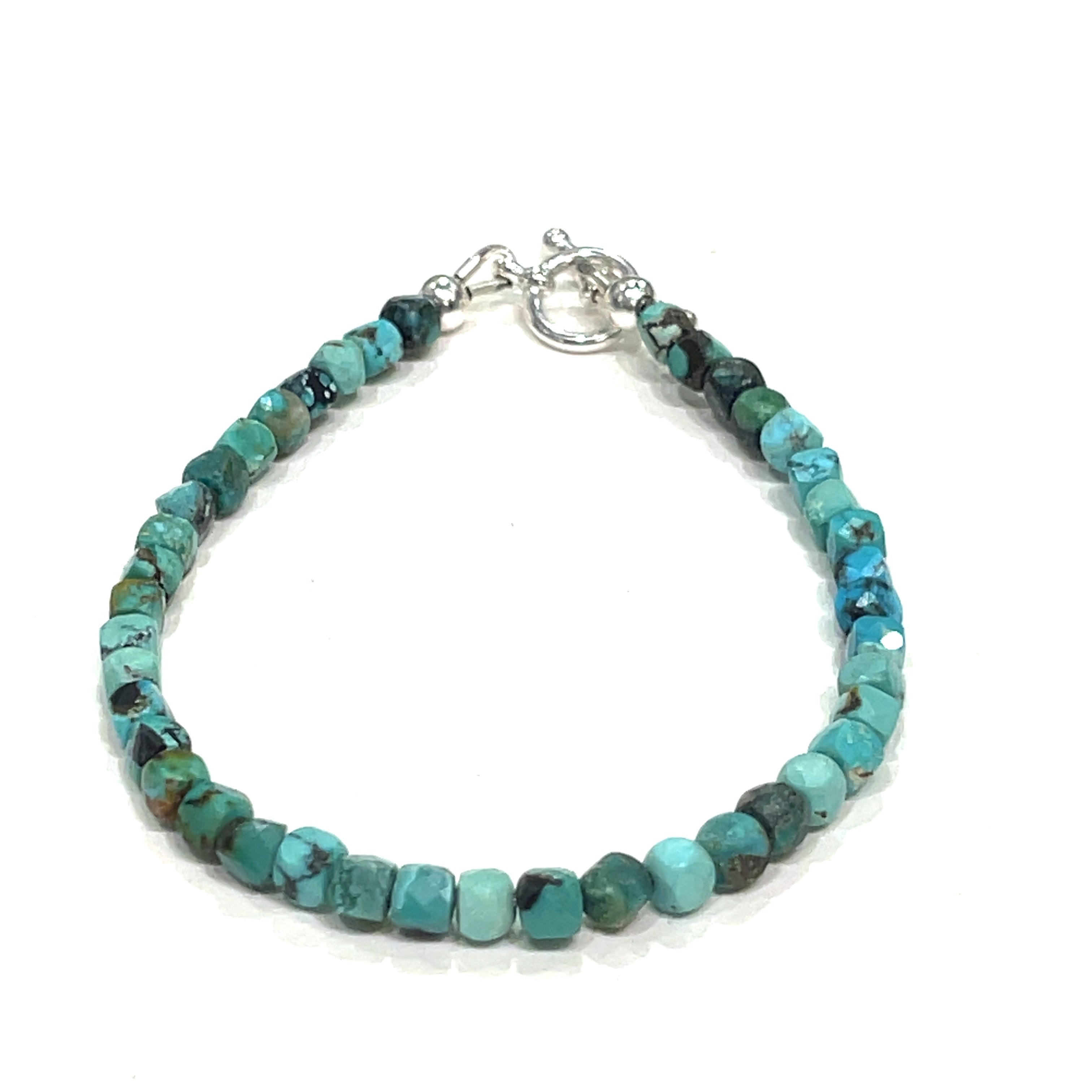 Top-grade Turquoise faceted cubed  beads strung on durable Beadalon wire with a sterling silver toggle on a white background  front view. 
