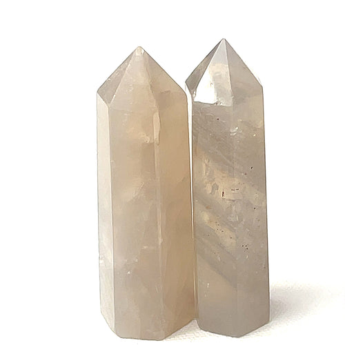Two Blue Rose quartz gemstone towers arranged together against a white background, front overview. 