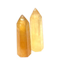 Two Honey Calcite gemstone tower displayed on a white background, front view.