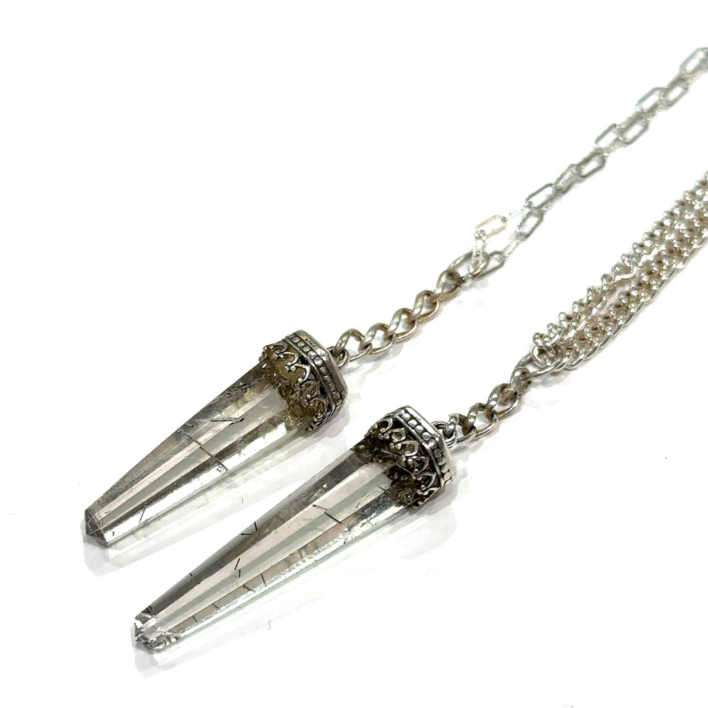 Two Rutilated Quartz pendants on a Sterling Silver chain necklace with intricate designs on the bezel caps on a white background, diagonal long view.
