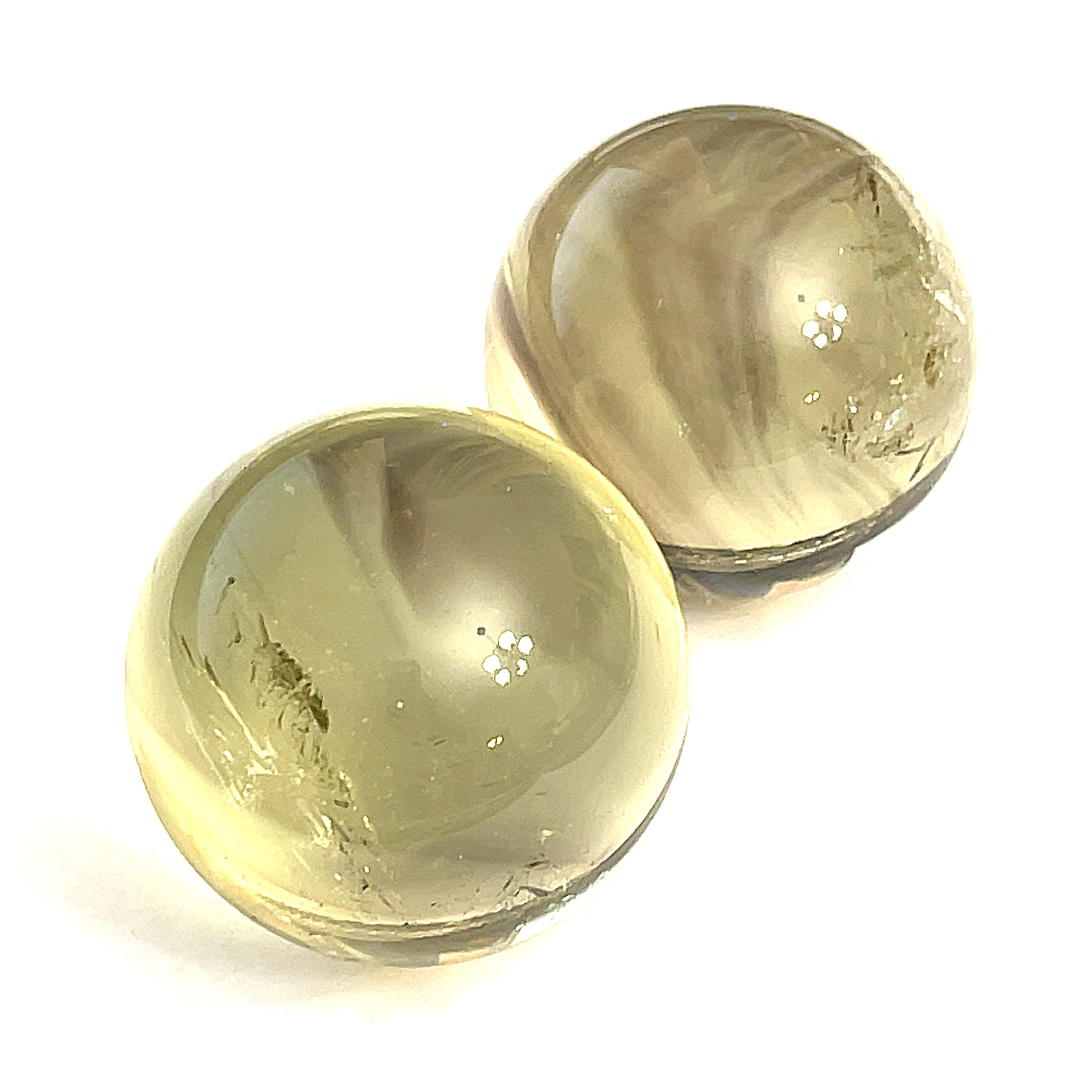  Two citrine gemstone sphere on a white background for a close up overview.