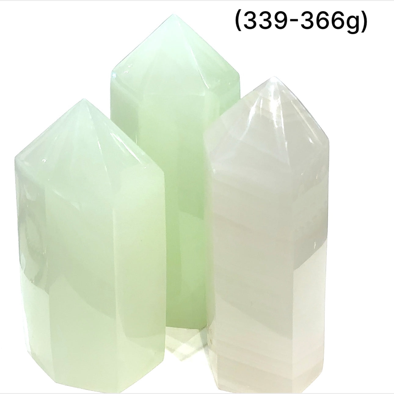 Two  green calcite gemstone towers (339-366g) on a white background, front overview.