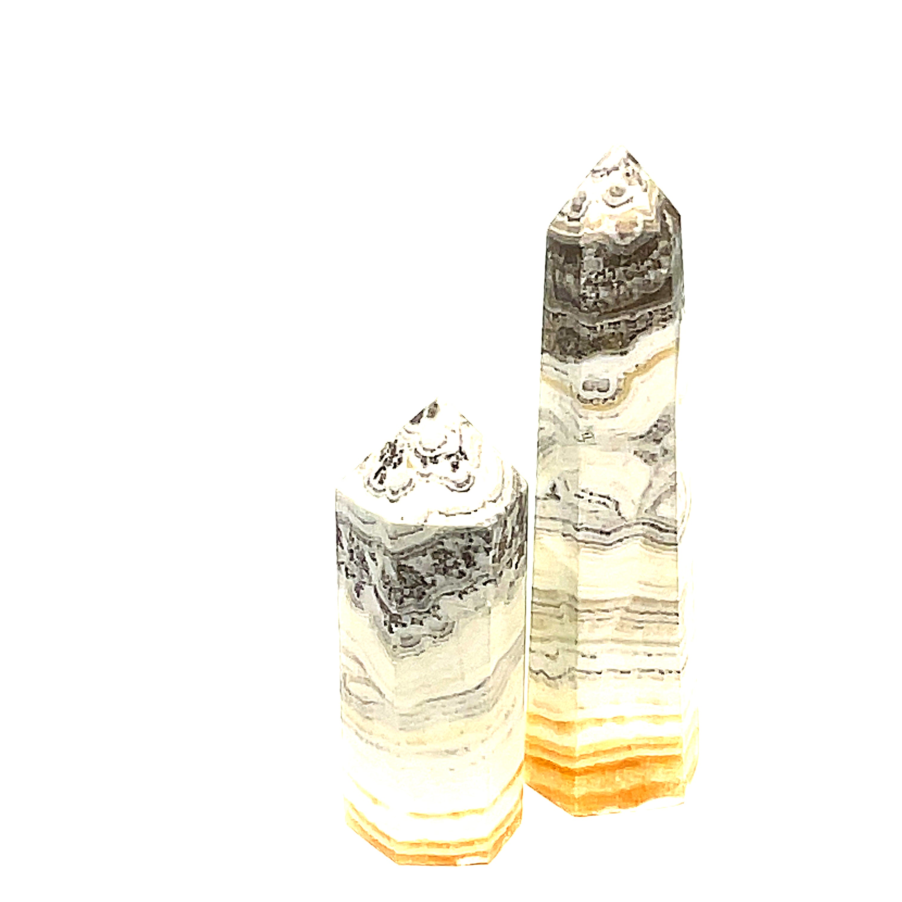 Two yellow calcite gemstone towers with black dendritic patterns against a white background, front view. 