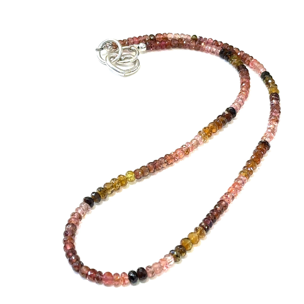Vibrant faceted Tourmaline gemstone necklace inspired by autumn garden colors on a white background long overview.