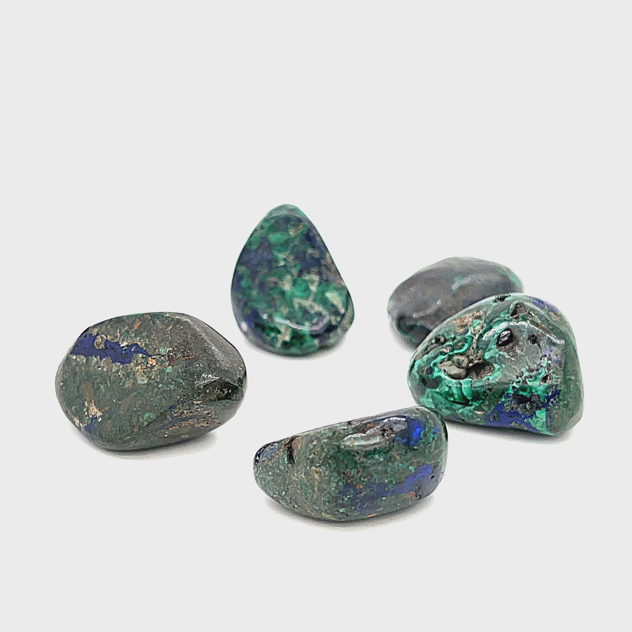 tumbled Azurite gemstone with visible Malachite inclusions on a white background, front view. video