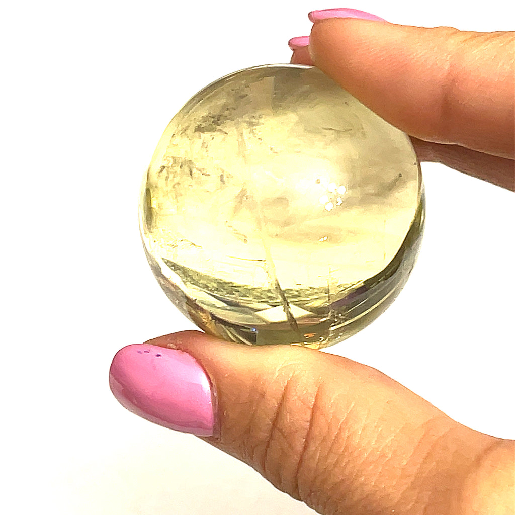  a large size citrine gemstone sphere held by a model on a white background for a close up overview.