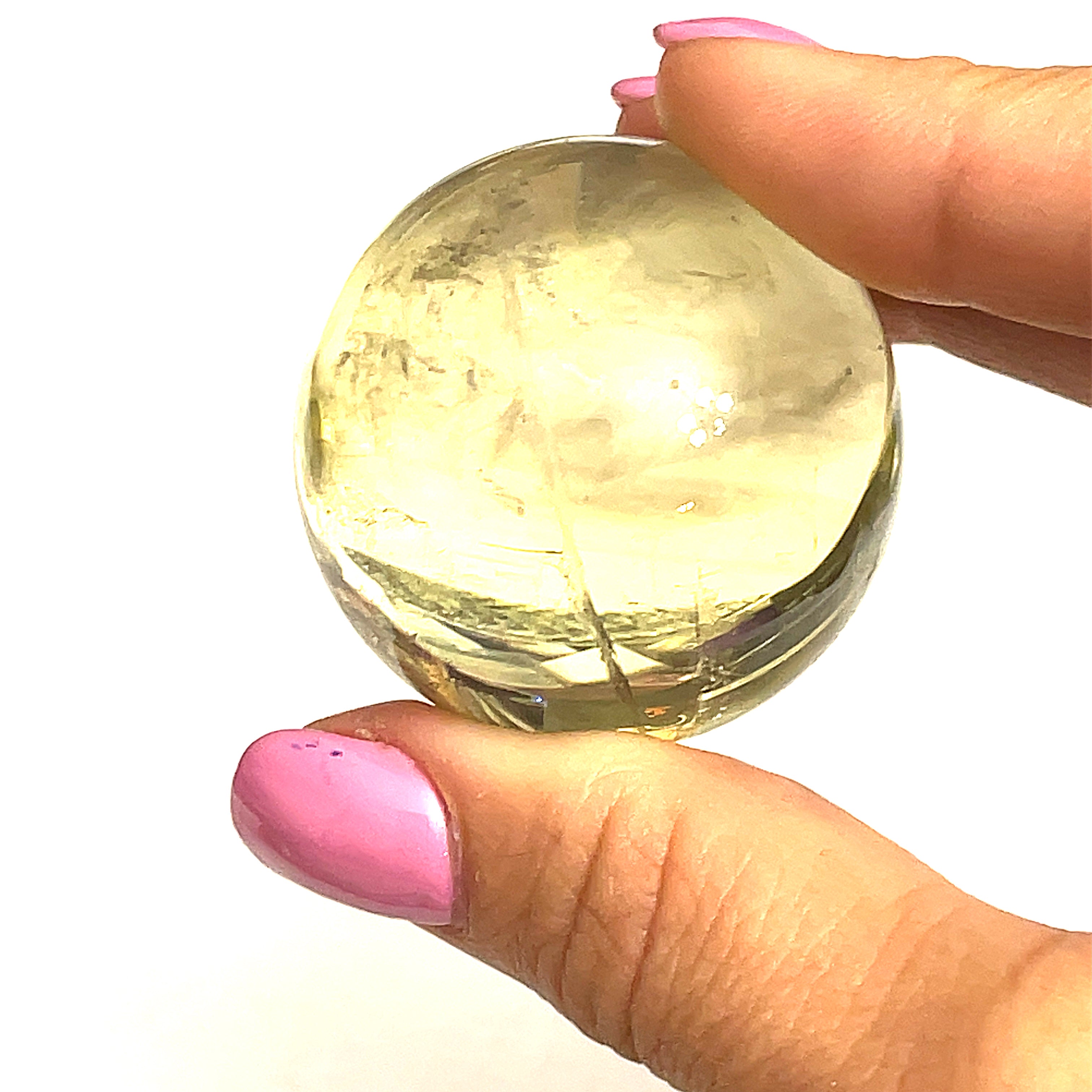  a large size citrine gemstone sphere held by a model on a white background for a close up overview.