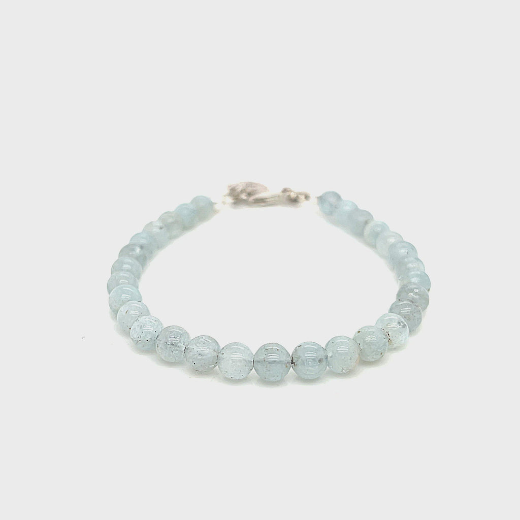 Aquamarine gemstone beaded bracelet with sterling silver lobster claw clasp showing pale blue translucent color on a white background front overview.  video