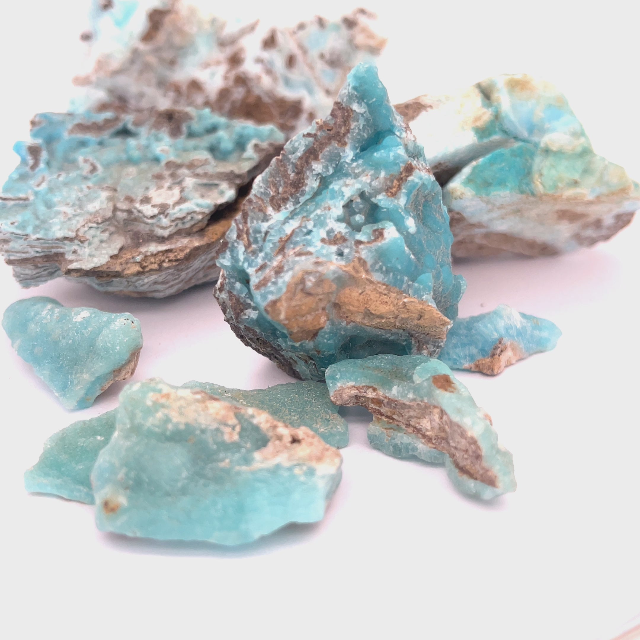 A large group of different sizes of raw Hemimorphite pieces on  a white background, front view. video