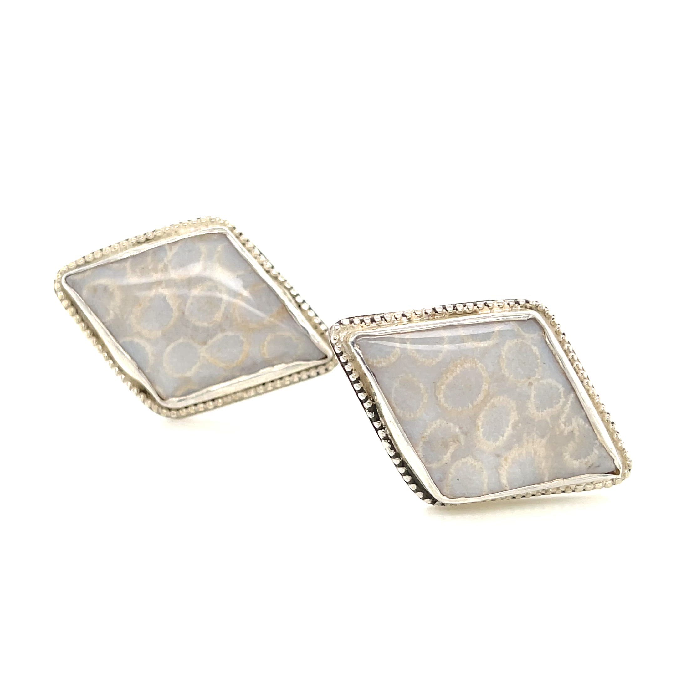 Handcrafted sterling silver fossil coral cuff links with beaded wire design on a white background center forward view. video