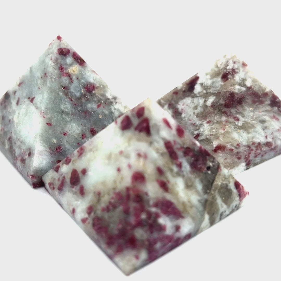 A Pink Tourmaline Pyramid used for heart chakra meditation and energy healing on a white background overview. viideo