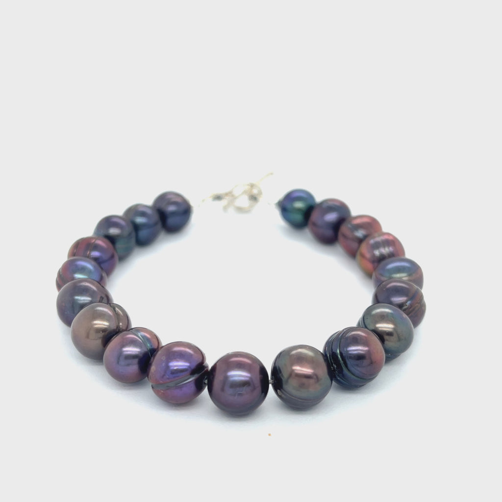 Close-up of Purple Freshwater Pearls showcasing luster and texture, handcrafted Boston jewelry on a white background front overview. video