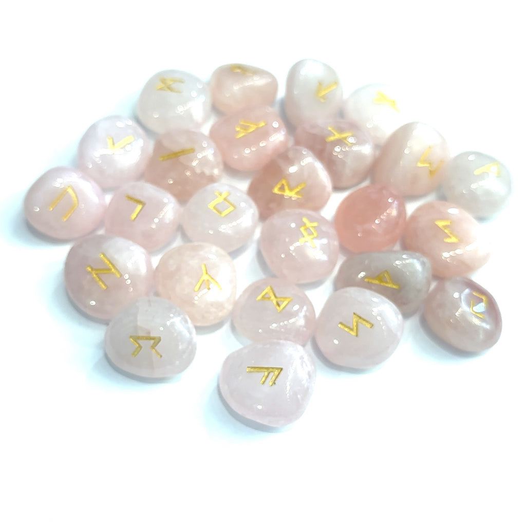 Gemstone rune set with engraved symbols on polished stones, representing divination and reflection rose quartz grouping on white overview